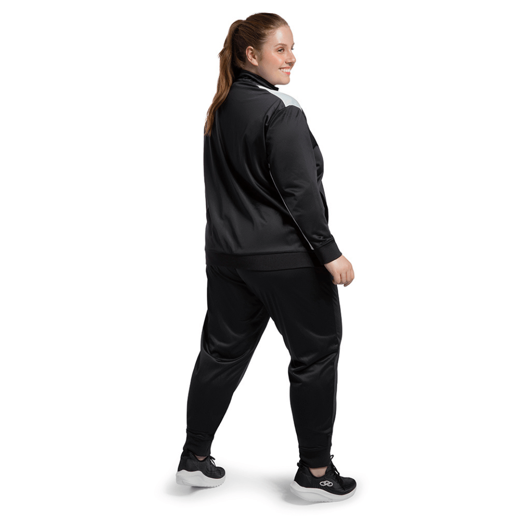 Mulher de frente usando Conjunto Agasalho preto Olympikus Essential destacando o ajuste e funcionalidade